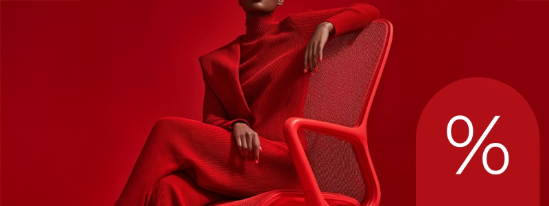 Persona sentada en una silla de diseño roja sobre un fondo rojo, con un símbolo de porcentaje a la derecha que indica un descuento.