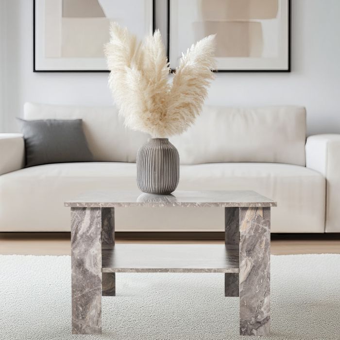 Mesa cuadrada para salón con un segundo nivel que sirve como superficie de apoyo. La mesa tiene un acabado integral en mármol gris.